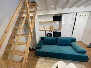 sala de estar con sofá azul y escalera de madera en Le Cordelier-Proche marché central et vieux port-wifi haut débit-, en La Rochelle