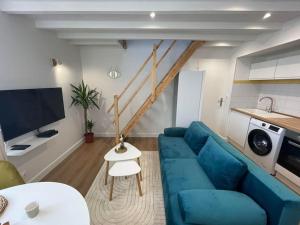 uma sala de estar com um sofá azul e uma televisão em Le Cordelier-Proche marché central et vieux port-wifi haut débit- em La Rochelle