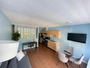 a living room with a kitchen and a desk with chairs at Downtown 1BR Condo at Granville Strip near English Bay in Vancouver