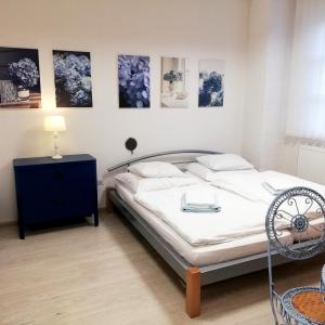 1 dormitorio con cama, mesa y cuadros en la pared en Guest House Factory, en Malacky
