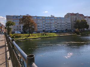 un puente sobre un río con un edificio al fondo en Apartament przy Motławie en Gdansk