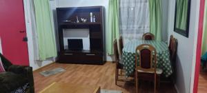 a dining room with a table and a television at El Adobe Chile Chico in Chile Chico