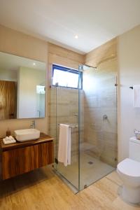 a bathroom with a shower and a sink and a toilet at Akbal Tulum in Tulum
