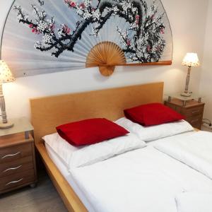 1 dormitorio con 2 almohadas rojas en una cama en Guest House Factory, en Malacky