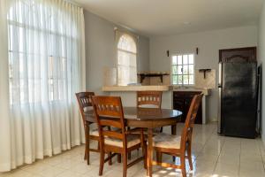a kitchen with a table and chairs and a refrigerator at Residencial Del Golf in La Lima