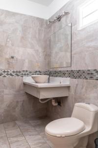 a bathroom with a sink and a toilet and a mirror at Residencial Del Golf in La Lima