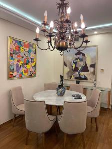 une salle à manger avec une table, des chaises et un lustre dans l'établissement Luxueux VILLA avec jardin et vue panoramique, à Tetouan