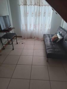 sala de estar con sofá de cuero negro y TV en Casa condominio, en Coquimbo