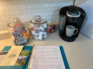 a book on a counter next to a coffee maker and a coffee pot at Avenue of the Giants Caraway Cottage (#3) 