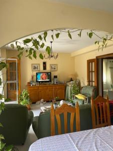 a living room with a tv and a table and chairs at Casa El Real de San Vicente in El Real de San Vicente