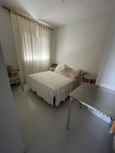 a small bedroom with a bed and a table at Casa El Real de San Vicente in El Real de San Vicente