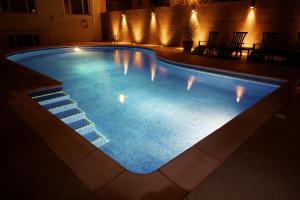 a swimming pool at night with lights on it at Hotel Savoy in Saint Helier Jersey