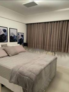 a bedroom with a large bed and some curtains at alto padrão itaim bibi in Sao Paulo