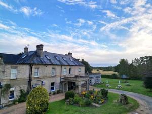 ein großes Steinhaus mit Garten davor in der Unterkunft Broom Hall Country Hotel in Saham Toney