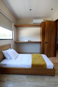 a bedroom with a bed and a window and shelves at Akbal Tulum in Tulum