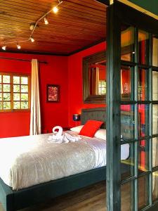 a bedroom with a bed with red walls at Arca de Noe in Valle Hornito