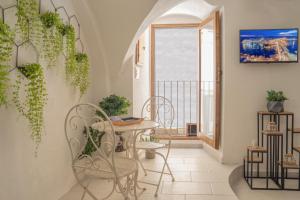 ガリポリにあるRomantic Suiteのテーブルと椅子、窓が備わる客室です。