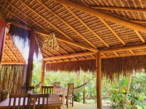um pavilhão de madeira com uma mesa e cadeiras por baixo em Casa Linda Boipeba na Ilha de Boipeba