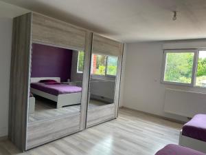 ein Schlafzimmer mit einem Spiegel und einem Bett darin in der Unterkunft IRIS 80 in Lorette