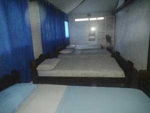 Un grupo de 4 camas en una habitación en CasaHotelMarly en Santa Marta
