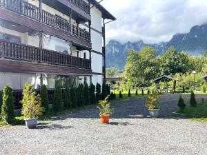 a building with two potted plants in front of it at Mountain River Loft in Buşteni