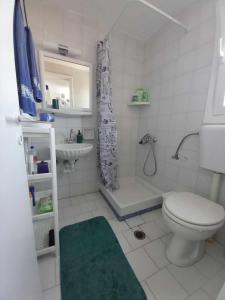 a white bathroom with a toilet and a sink at Serenity Maisonnette in Otzias