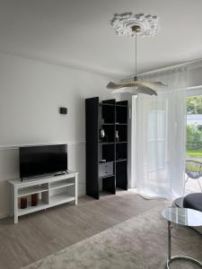 uma sala de estar branca com uma televisão e uma mesa em Paris to Bochum, 4 Pers. Apartm. em Bochum