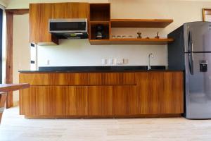 a kitchen with wooden cabinets and a stainless steel refrigerator at Akbal Tulum in Tulum