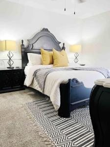 ein Schlafzimmer mit einem großen Bett mit gelben Kissen in der Unterkunft NEW Magnolia Mansion-4400sqft Hot Tub & 2 Game Rms in Lubbock