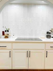 uma cozinha com armários brancos e um lavatório em NEW Magnolia Mansion-4400sqft Hot Tub & 2 Game Rms em Lubbock