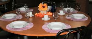 a wooden table with plates and wine glasses on it at Casa Dănuț in Reşiţa +3 photos