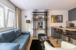 Il comprend un salon avec un canapé bleu et une cuisine. dans l'établissement The Urban Cukor Suite, à Zagreb