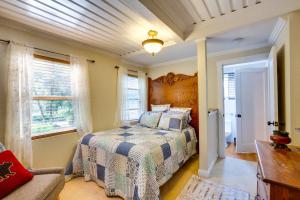 a bedroom with a bed and a couch and a window at Historic Mapleton Cottage with River Views and Hot Tub in Mapleton