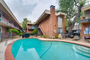 a swimming pool in front of a building at Luxe and Modern Dallas Condo 2 Mi to Highland Park! in Dallas