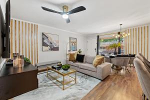 a living room with a couch and a ceiling fan at Luxe and Modern Dallas Condo 2 Mi to Highland Park! in Dallas