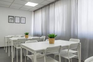 T&K Apartments 6 and 10 Room Apartment in Neuss for big Groups 22min to Fair DUS في نويس: غرفة بطاولات بيضاء وكراسي بيضاء وستائر