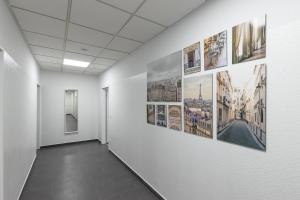 a hallway with pictures on the walls of a building at T&K Apartments 6 and 10 Room Apartment in Neuss for big Groups 22min to Fair DUS in Neuss