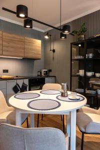 - une cuisine avec une table et des chaises dans la chambre dans l'établissement Apartament PrzystańTu Relax&Spa, à Dziwnów