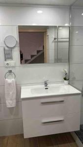 uma casa de banho branca com um lavatório e um espelho em Apartamento Murcia San José A em Múrcia