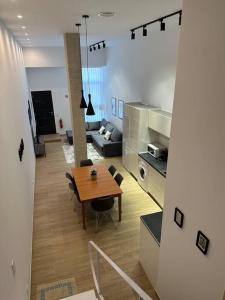 a living room with a wooden table and a kitchen at Apartamento Murcia San José A in Murcia
