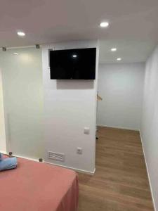 um quarto com uma televisão de ecrã plano na parede em Apartamento Murcia San José A em Múrcia