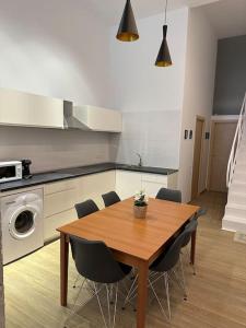 uma cozinha com uma mesa de madeira e cadeiras num quarto em Apartamento Murcia San José A em Múrcia