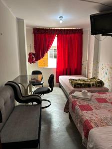 a hotel room with two beds and a red window at La Esquina de Doña Julia in Lima