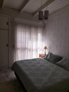 Un dormitorio con una cama grande y una ventana en Duplex costanera en Monte Hermoso