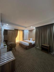 ein Hotelzimmer mit einem Bett und einem Schreibtisch in der Unterkunft شقق الكوثر الفندقية in Mekka