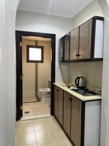 eine Küche mit einem Waschbecken und einem WC in einem Zimmer in der Unterkunft شقق الكوثر الفندقية in Mekka