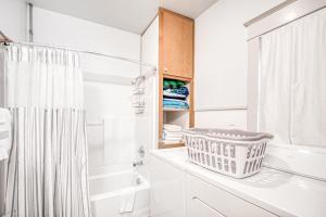 a white bathroom with a shower curtain and a tub at South Sandpoint Charmer in Sandpoint +49 photos