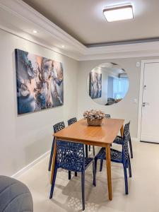 a dining room with a wooden table and chairs at Brisa Mar Apartamento Aconchego in Balneário Camboriú
