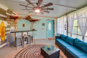 a living room with a blue couch and a ceiling fan at Tarpon Springs Family Getaway with Patio and Hot Tub! in Tarpon Springs