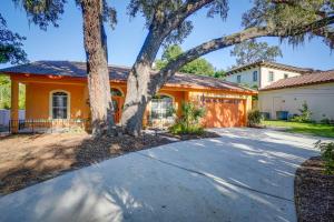 a house with a tree in front of a driveway at Tarpon Springs Family Getaway with Patio and Hot Tub! in Tarpon Springs